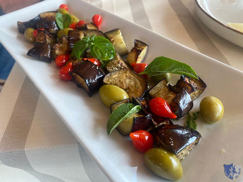 Melanzane a tocchetti olive peperoncini dolci e foglie di basilico