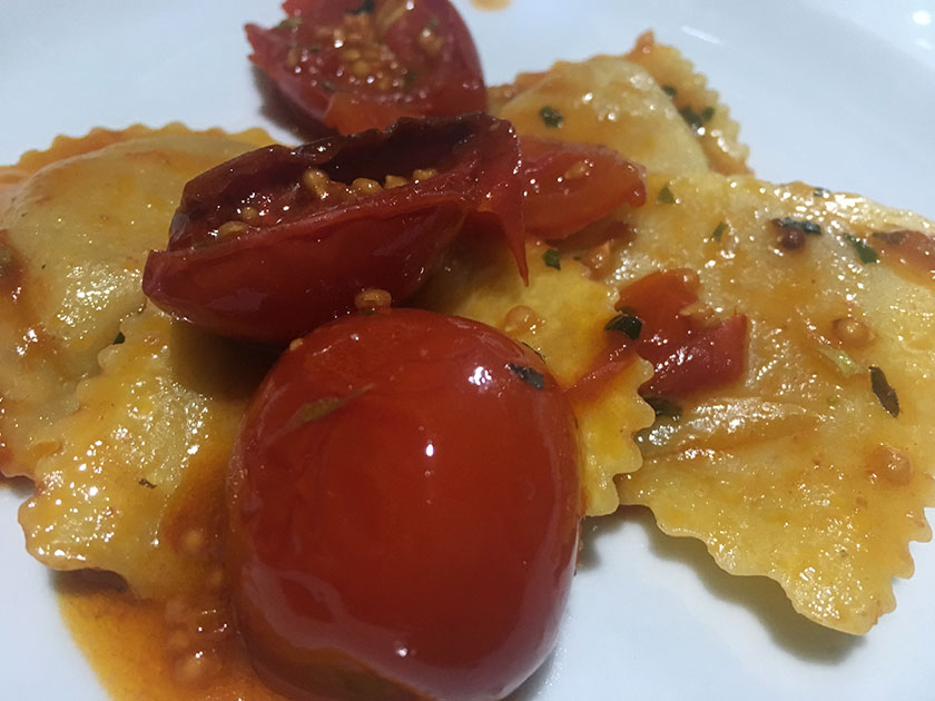 Ravioli ripieni di noci e caprino con pomodorini infornati e basilico