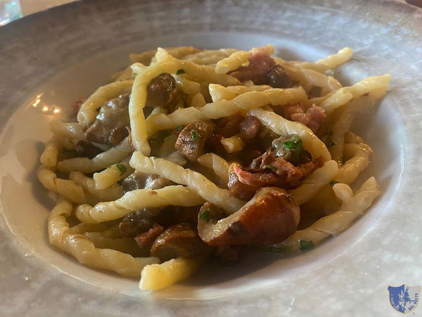 Fusilli ricci freschi con porcini salsiccia piccante e formaggio