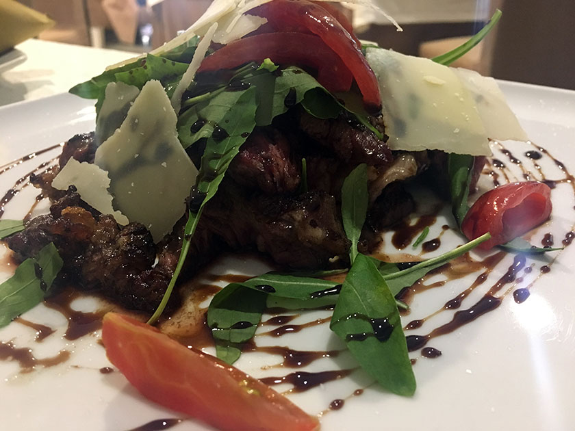 Tagliata di manzo con rucola scaglie di parmigiano pomodorini e riduzione di balsamico