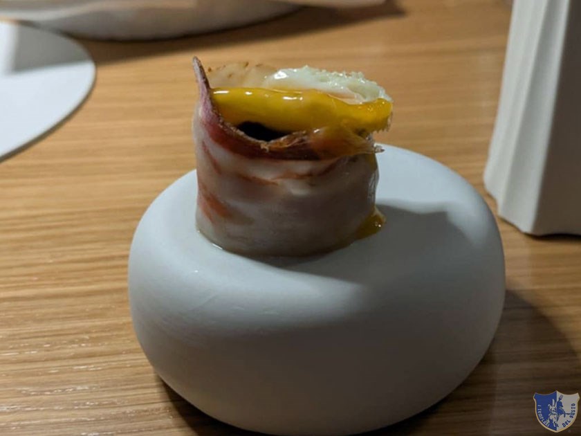 Uovo di quaglia su letto di pancetta arrotolata