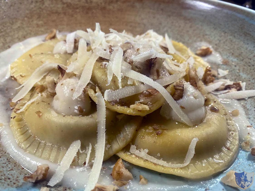 Ravioli ripieni di mascarpone e noci adagiati su mousse di cavolo con Brie scorzetta di limone e granella di noci