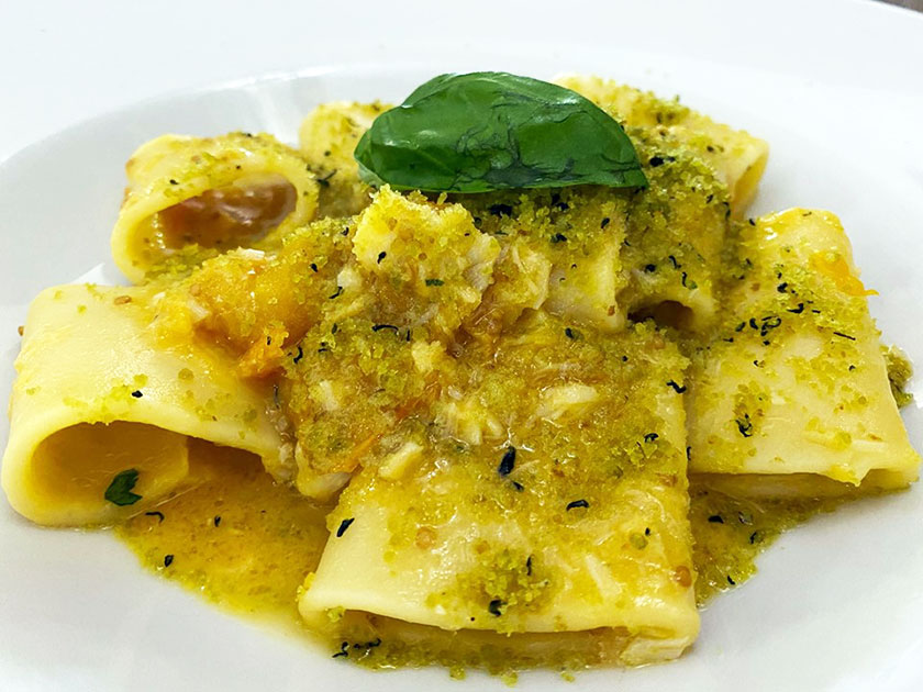 Paccheri con ragù di datterino giallo baccalà mollica di pane fritto e basilico