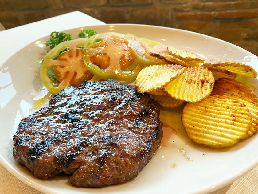 Hamburger con patate rustiche e pomodoro di stagione a fette