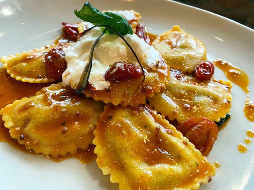 Mezzaluna di pasta fresca ripiena di ricotta e melanzana con pomodorini e stracciata di bufala