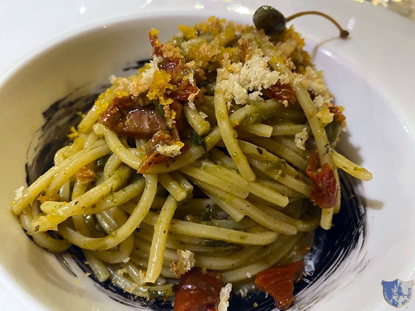 Spaghetti allaglio nero con crema di spigatelli acciughe briciole croccanti pomodori secchi bottarga di muggine e stracciatella