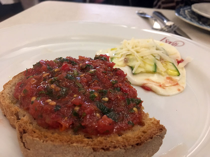 Bruschetta con battuto di datterini dolci e parmigianina di zucchine crude a mò di carpaccio