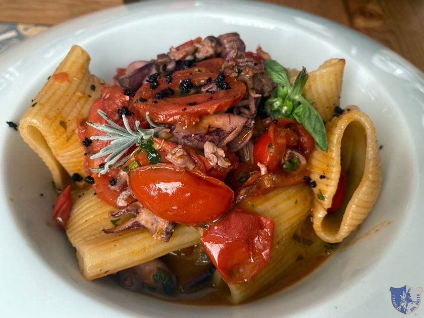 Mezzi paccheri con pomodorini del piennolo calamarelle e olive caiazzane