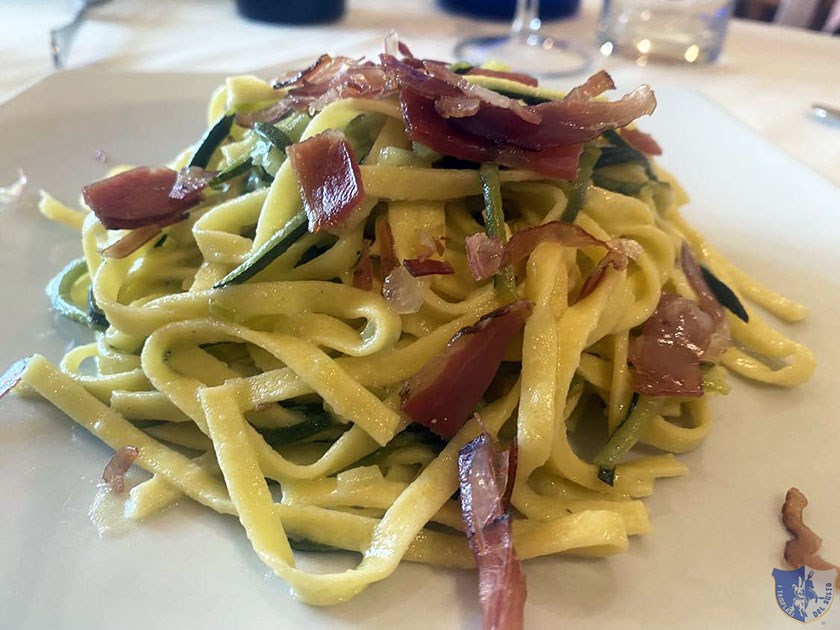 Fettuccine con fiori di zucca julienne di zucchine e speck croccante