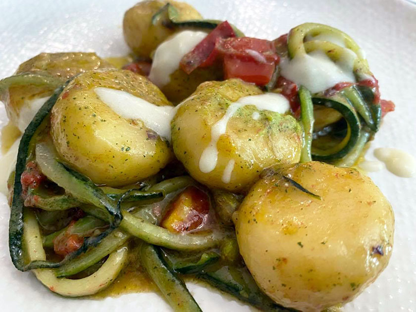 Gnocchi ripieni con taleggio e pistacchio con zucchine e pomodorini