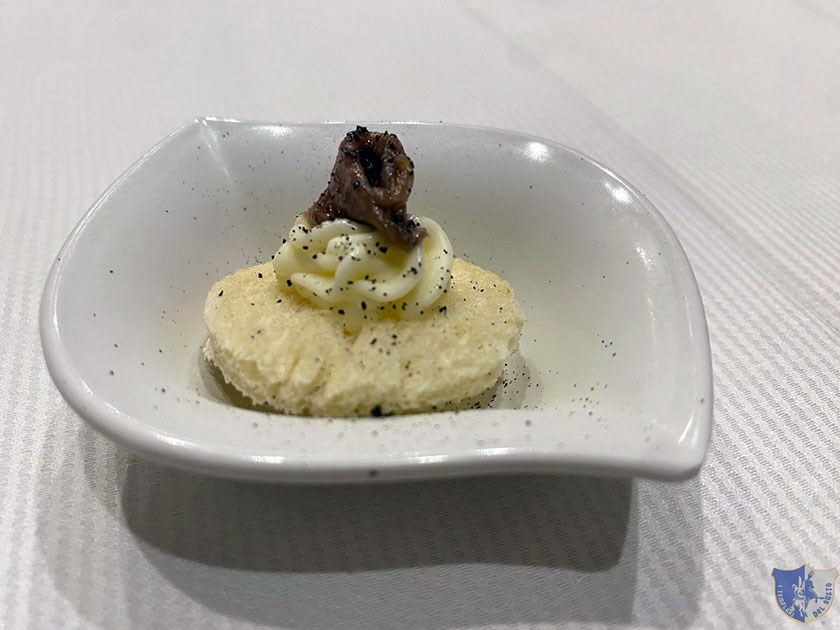 Amous bouche dello chef con calice di prosecco Tartina con burro e acciuga
