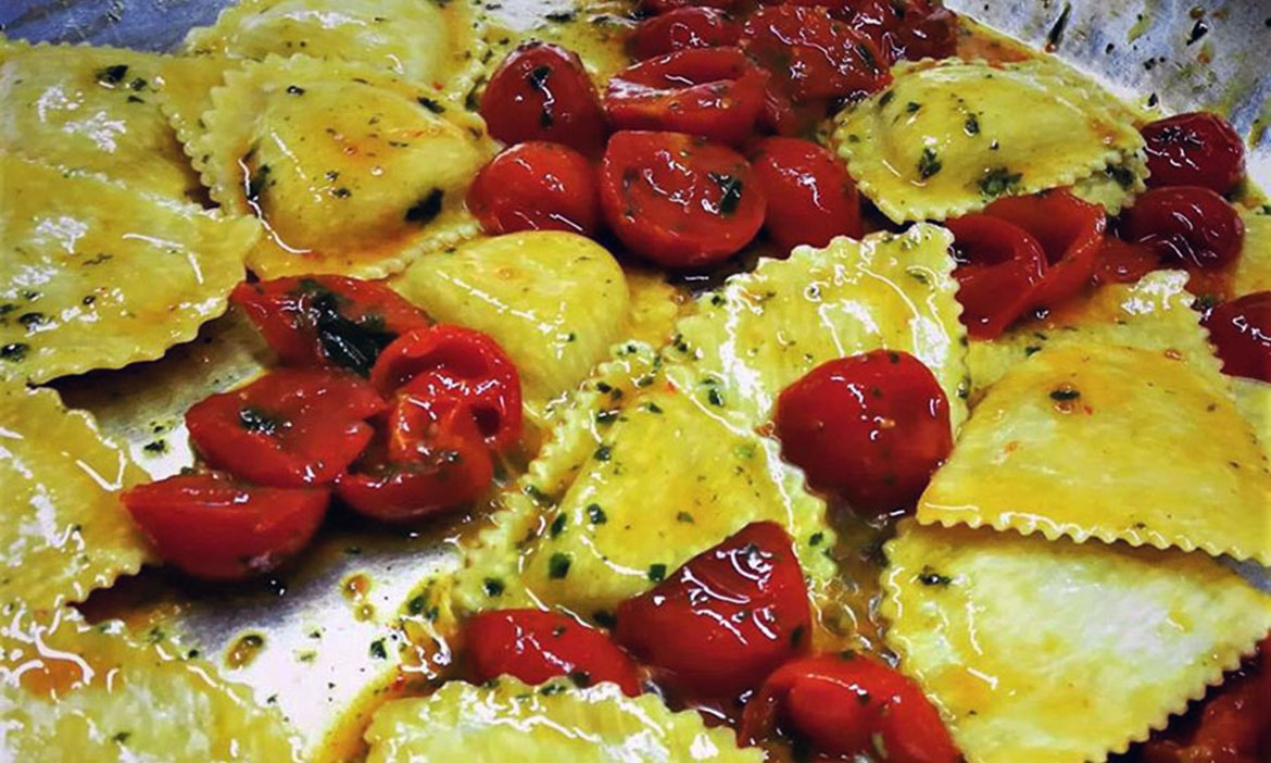 Ravioli al caprino e noci con pesto di basilico e pomodorini confit