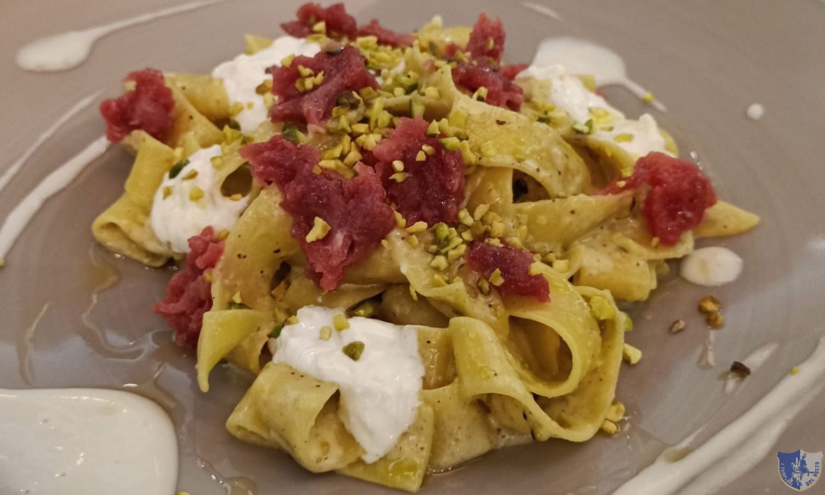 Pappardelle con battuta di fassona, stracciata di bufala e pesto di pistacchio.